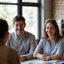 Mosolygó alkalmazottak, akik egy csapatépítő workshopon vesznek részt, aktívan kommunikálnak és együtt dolgoznak.